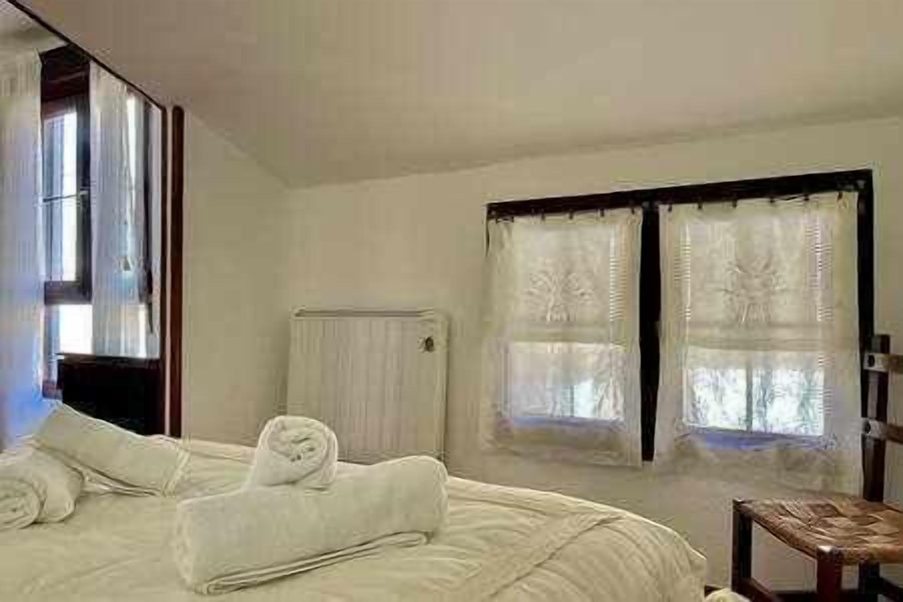 Une chambre à coucher avec un lit, une chaise en bois et un radiateur.