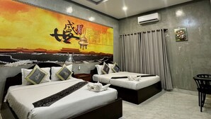 Une chambre d’hôtel moderne avec un grand lit, un lit plus petit et un bureau.