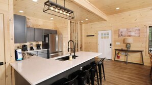 Una cucina moderna con una grande isola, elettrodomestici in acciaio inossidabile e finiture in legno.