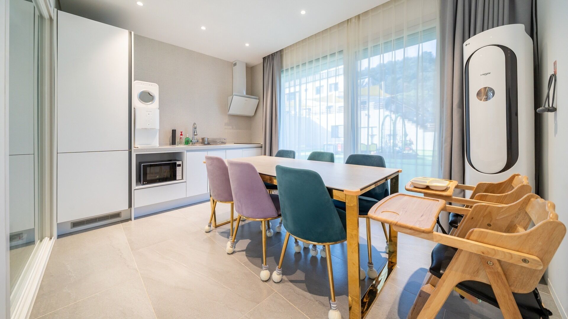 Una cocina moderna con comedor, que incluye una mesa y sillas, y un aire acondicionado integrado.