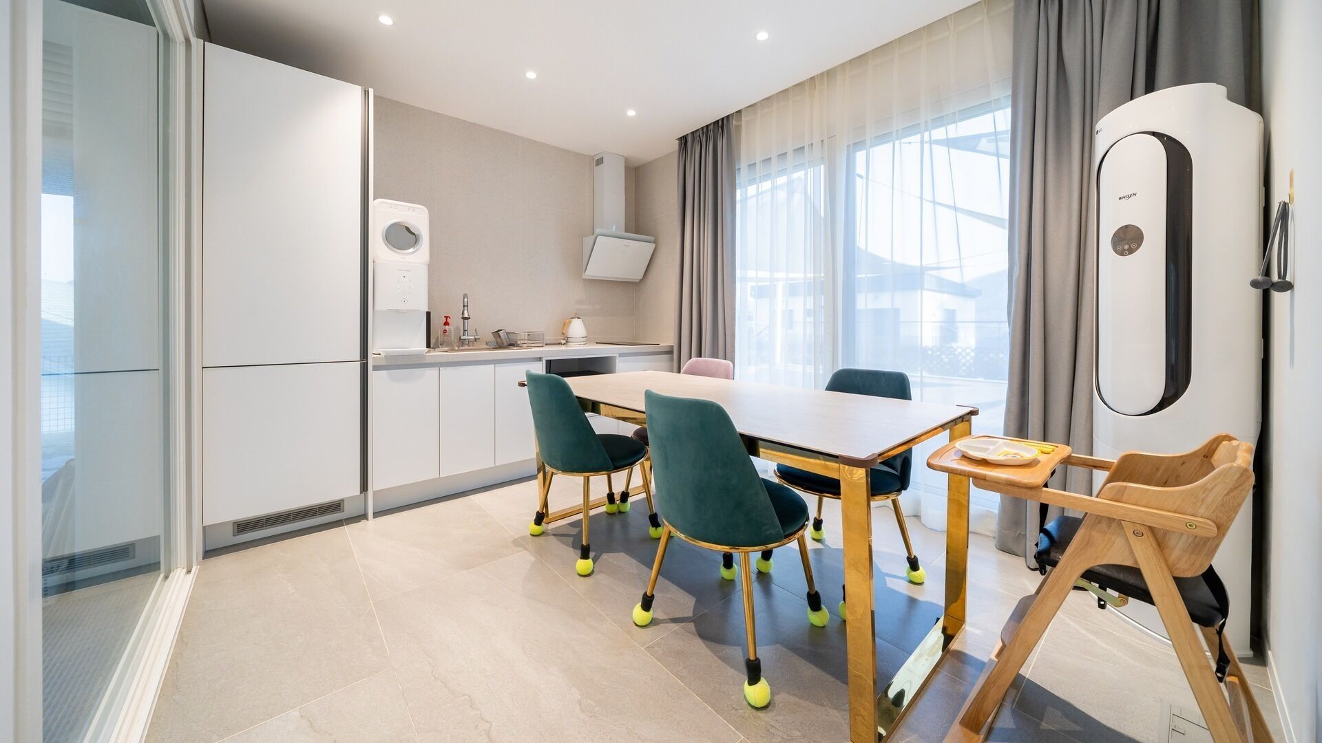 Una cocina moderna con comedor, que incluye una mesa, sillas y un horno empotrado.