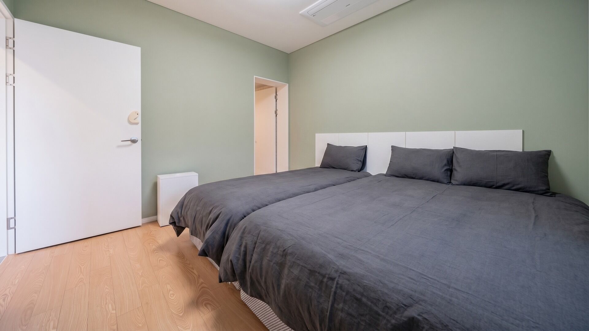 Une chambre à coucher avec un lit double, une porte blanche et un radiateur.