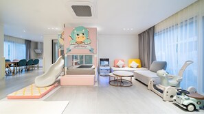 Ein Spielbereich für Kinder mit Rutsche, Spielkonsole und Spielzeugauto.