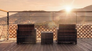 A wooden deck with wicker furniture and a view of a hilly landscape. - Gapyeong Pinetree Kids Pool Villa (Gapyeong)