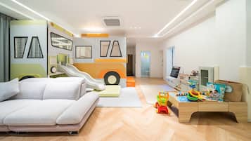 A modern children's playroom with a sofa, play area, and a TV.
