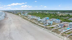 Zona residencial costera con propiedades frente al mar, incluyendo casas con balcones y piscina.