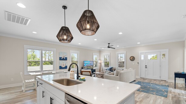 A modern kitchen with a large island, pendant lights, and a view of the outdoors. - "Just Peachy" 3BR Home | 4 Baths (2 Full, 2 Half) (Oak Island)