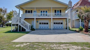 Une maison à deux étages avec un porche à l’avant, un escalier et un garage.
