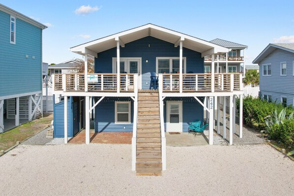 A two-story house with a balcony, a front porch, and a small deck.