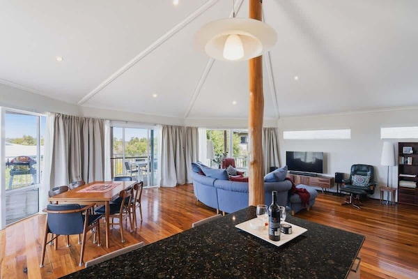 Come together in the sun-drenched living room beneath soaring timber ceilings.