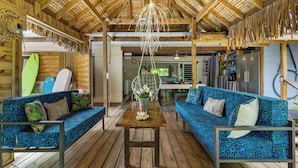 A wooden deck with two blue patterned sofas and a wooden table. - Fare Oaoa Haapiti (Moorea-Maiao)