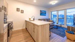 A modern kitchen with wooden cabinets, a central island, and a built-in oven. - Modern 2BR in Golden w/ Stunning  MTN Views! (Golden)