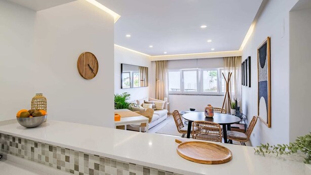A modern kitchen with a white countertop, a wooden cutting board, and a bowl of fruit. - Sea View in Estoril by Portugal Portfolio (Estoril)