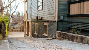 Un chemin menant à une maison dont les fondations sont en pierre et le revêtement extérieur en bois.