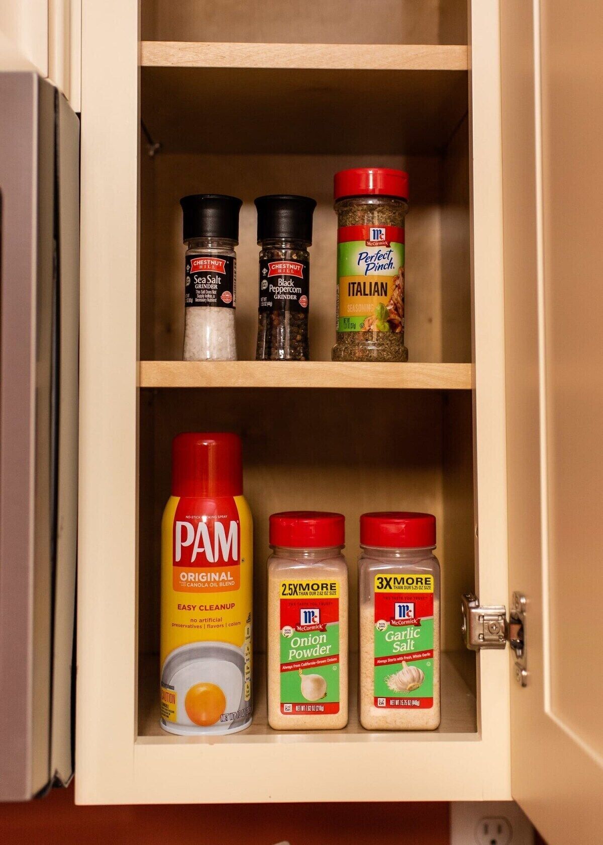 A kitchen cabinet with various spices and condiments.