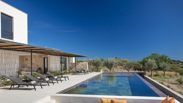 A modern poolside area with lounge chairs and a clear blue pool. - Villa Amore 8 Emma Villas (Avola)
