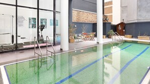 An indoor swimming pool with clear lanes, a changing room with exercise equipment, and a seating area with a view of the outside. - Darlinghurst — Newly renovated 1BR + Parking (City of Sydney)