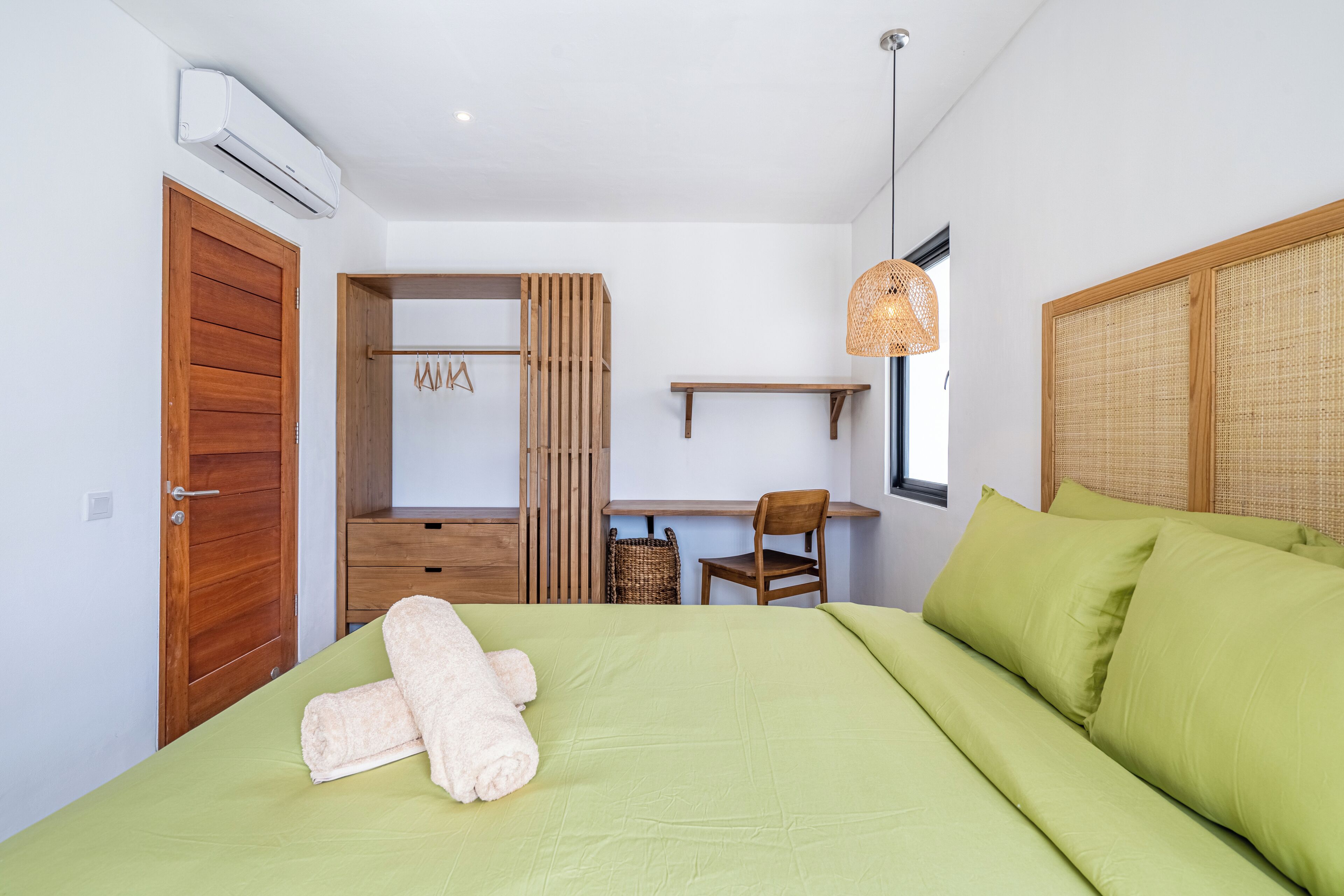 Camera da letto con un letto, una scrivania, una sedia, un armadio e una lampada a sospensione.