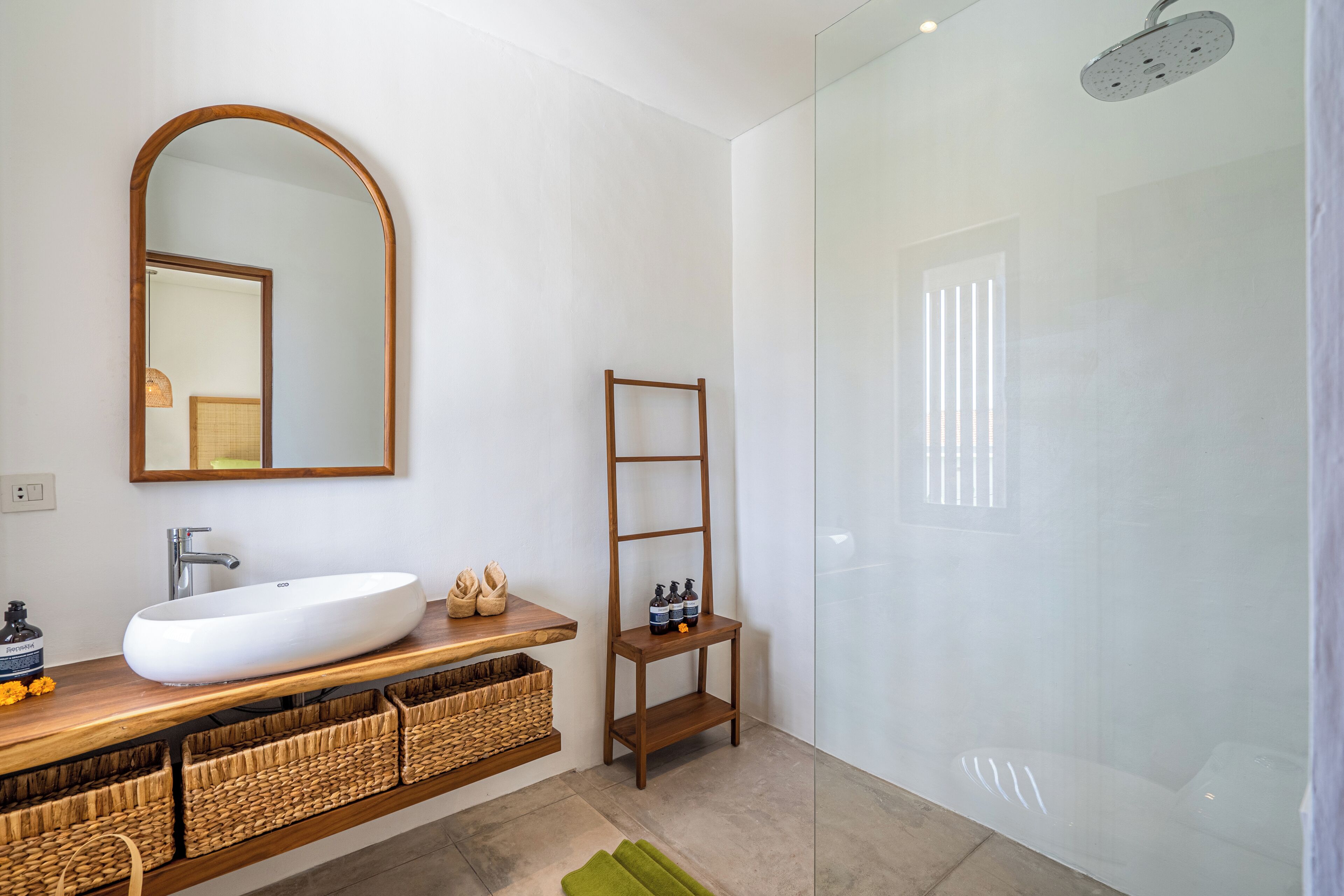 A modern bathroom with a large sink, mirror, and shower.