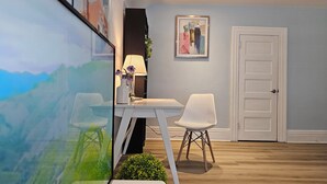 A modern room with a white desk, two white chairs, a lamp, and a framed abstract painting on the wall. - Winnipeg Holiday (Winnipeg)