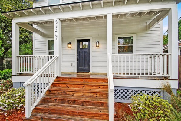 A two-story house with a porch, wooden steps, and a black front door. - Near Park Circle, Downtown, & Beaches | Pool Table (Hanahan)