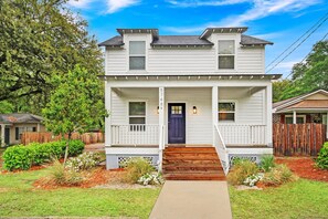 A two-story house with a front porch, a blue door, and a number '5748' on the wall. - Near Park Circle, Downtown, & Beaches | Pool Table (Hanahan)