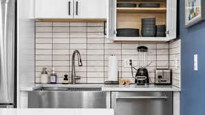 A modern kitchen with stainless steel appliances, a built-in dishwasher, and a countertop with a blender and toaster. - Guest Favorite- Denver Getaway Gem with Grill, Corn Hole, Basketball Court (Denver)