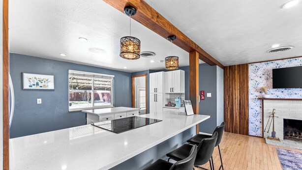 A modern kitchen with a central island, bar stools, and pendant lighting. - Guest Favorite- Denver Getaway Gem with Grill, Corn Hole, Basketball Court (Denver)