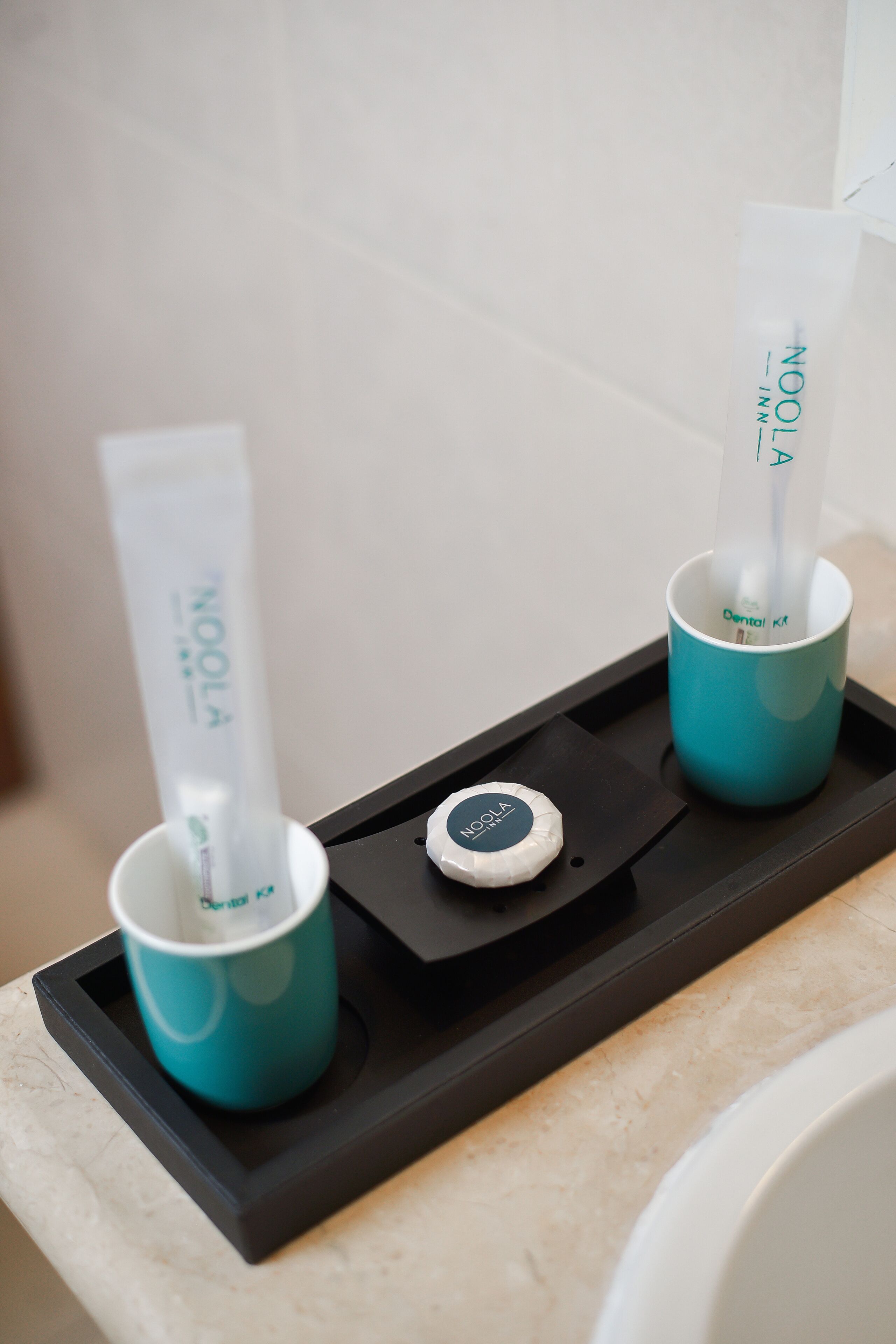 A tray with two teal cups and a dental kit.
