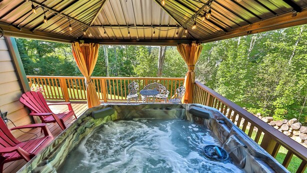 A hot tub with a wooden deck, surrounded by Adirondack chairs and a wooden railing. - New Luxuary Hunter Ski Resort&Lake Chalet, Hot Tub, Sauna, Fireplace, Mountains (Hunter)