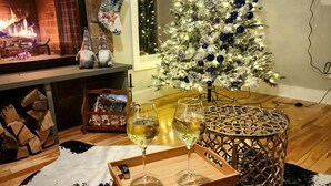 A cozy living room with a fireplace, a Christmas tree, and a tray with wine glasses. - New Luxuary Hunter Ski Resort&Lake Chalet, Hot Tub, Sauna, Fireplace, Mountains (Hunter)