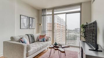 Relax in this stylish living room with a city view, featuring a sofa, side table, and flat-screen TV.