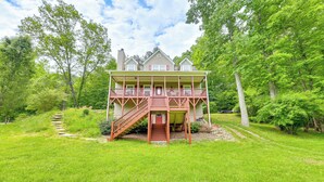 A two-story house with a front porch, a staircase leading to the entrance, and a well-maintained lawn. - Hammocks & Forest Views: Creekside Murphy Retreat (Murphy)