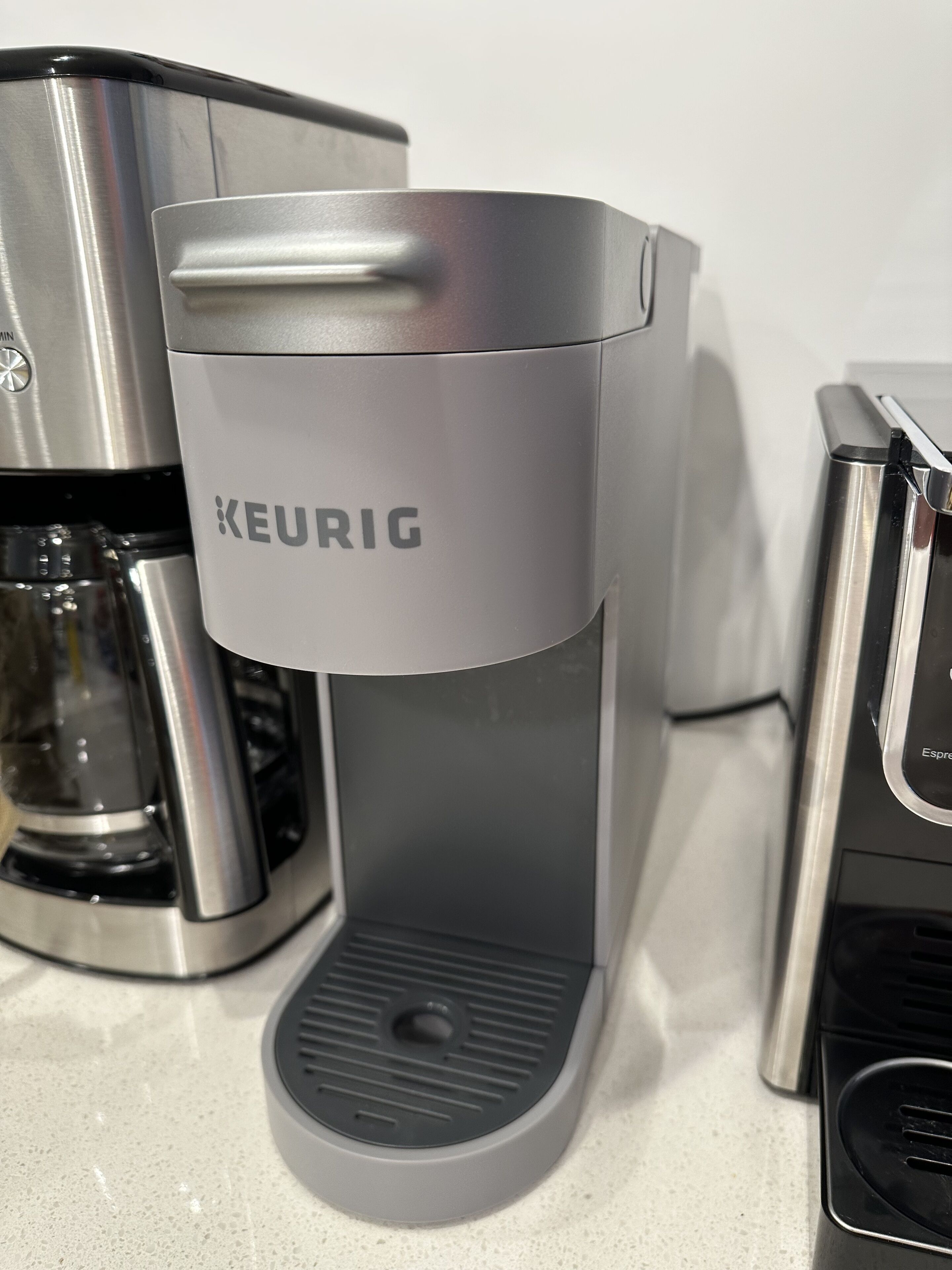 Una cafetera Keurig con depósito de agua y bandeja de goteo.