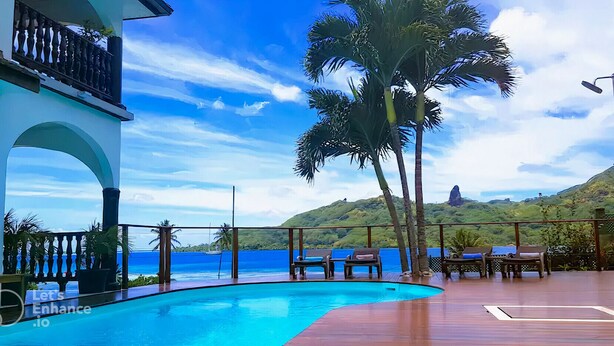 Zona de piscina con vista al océano y a la montaña.