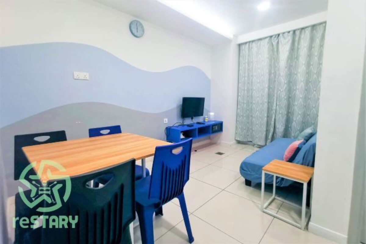 A compact living space with a dining area, a television, and a sofa.