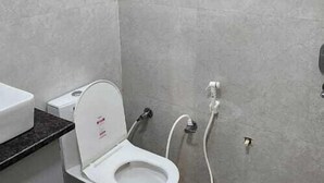 A bathroom with a toilet, a shower, and a sink. - Hotel Govardhan Inn (Mathura)