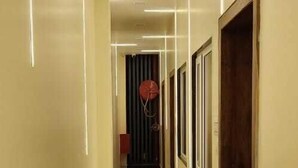 A hallway with marble flooring and modern lighting fixtures. - Hotel Govardhan Inn (Mathura)