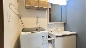 A compact kitchenette with a built-in refrigerator, a sink, and a microwave.