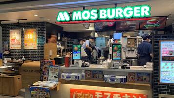 A fast-food restaurant with a bright sign reading "MOS BURGER".