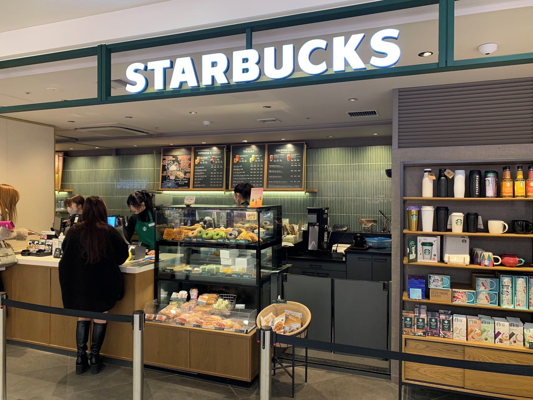A Starbucks coffee shop with a counter, display cases, and shelves with coffee products.