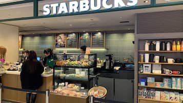 A Starbucks coffee shop with a counter, display cases, and shelves with coffee products.