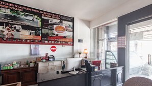 Una cocina moderna con electrodomésticos de acero inoxidable, un armario de madera y un cartel grande que anuncia gabinetes de cocina.