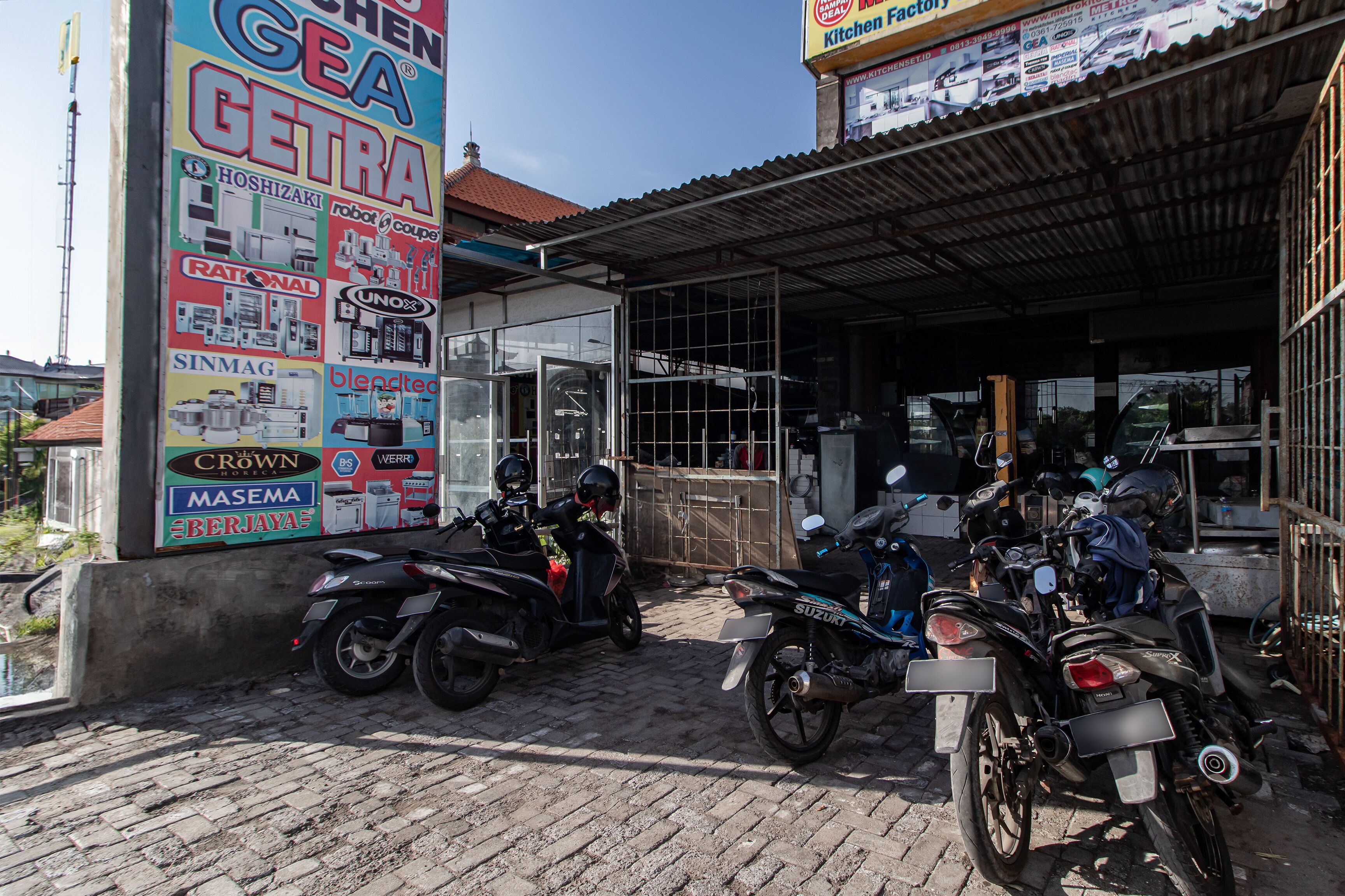 A motorcycle repair shop with two motorcycles parked in front.