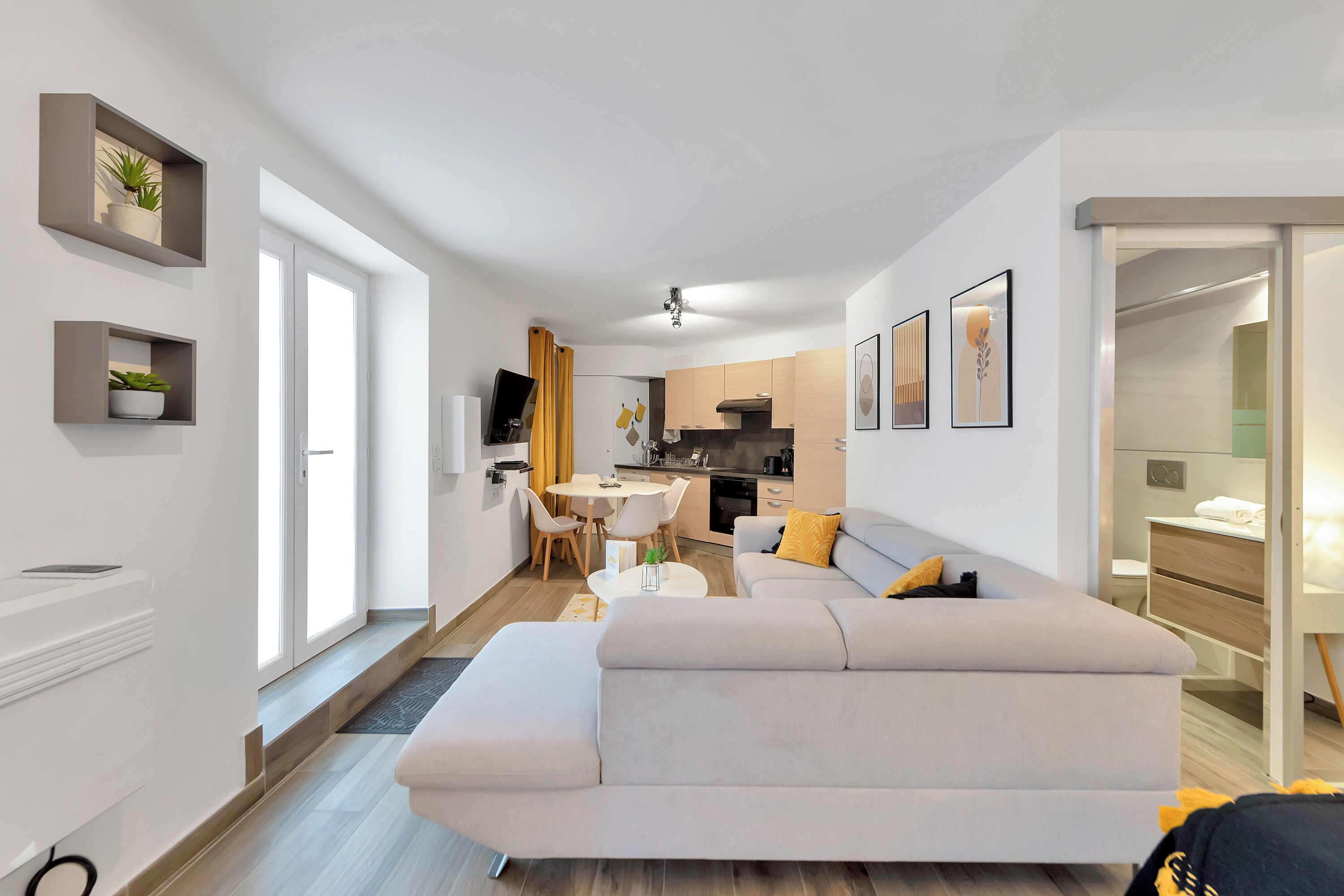 A modern apartment with a living room, dining area, and kitchen.