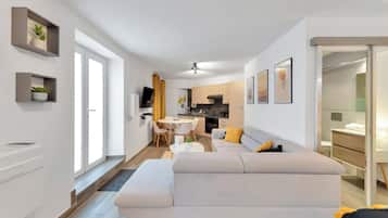 A modern apartment with a living room, dining area, and kitchen.
