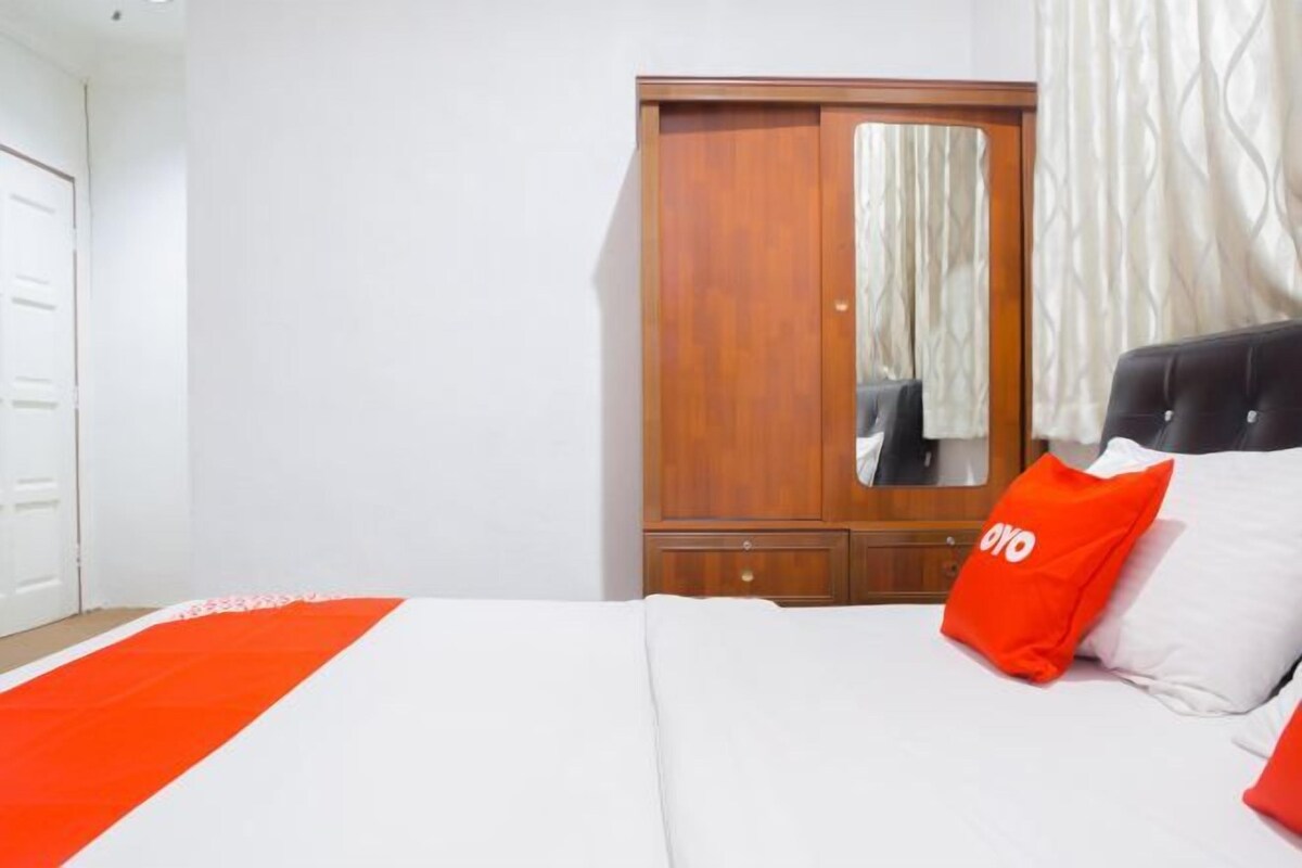 A bedroom with a bed, a wardrobe, and a mirror.