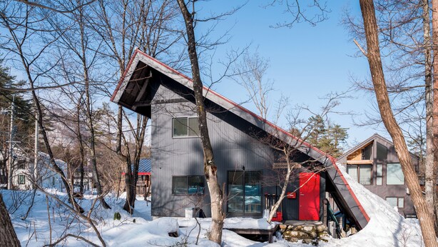 A modern building with a sloped roof, surrounded by trees and snow. - KONAYUKI CABIN HAKUBA (Hakuba)