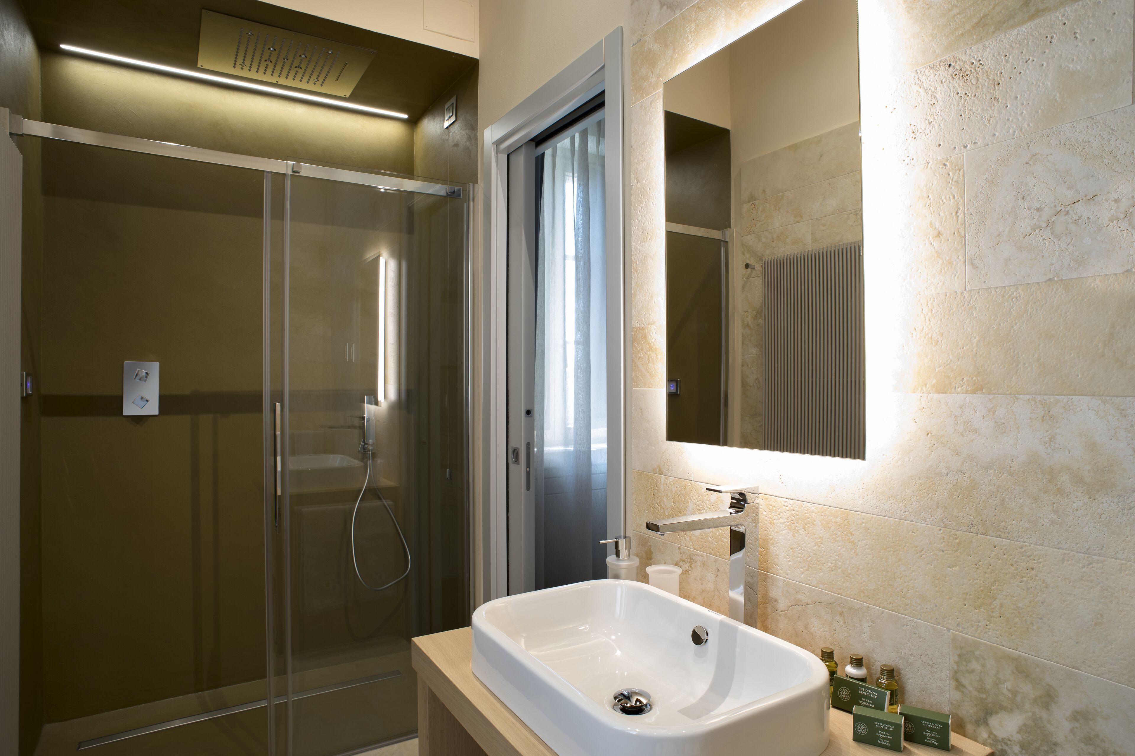 A modern bathroom with a glass-enclosed shower, a large sink, and a mirror above it.