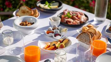 A breakfast table with various dishes, including toast, fruit, and a bowl of cereal.